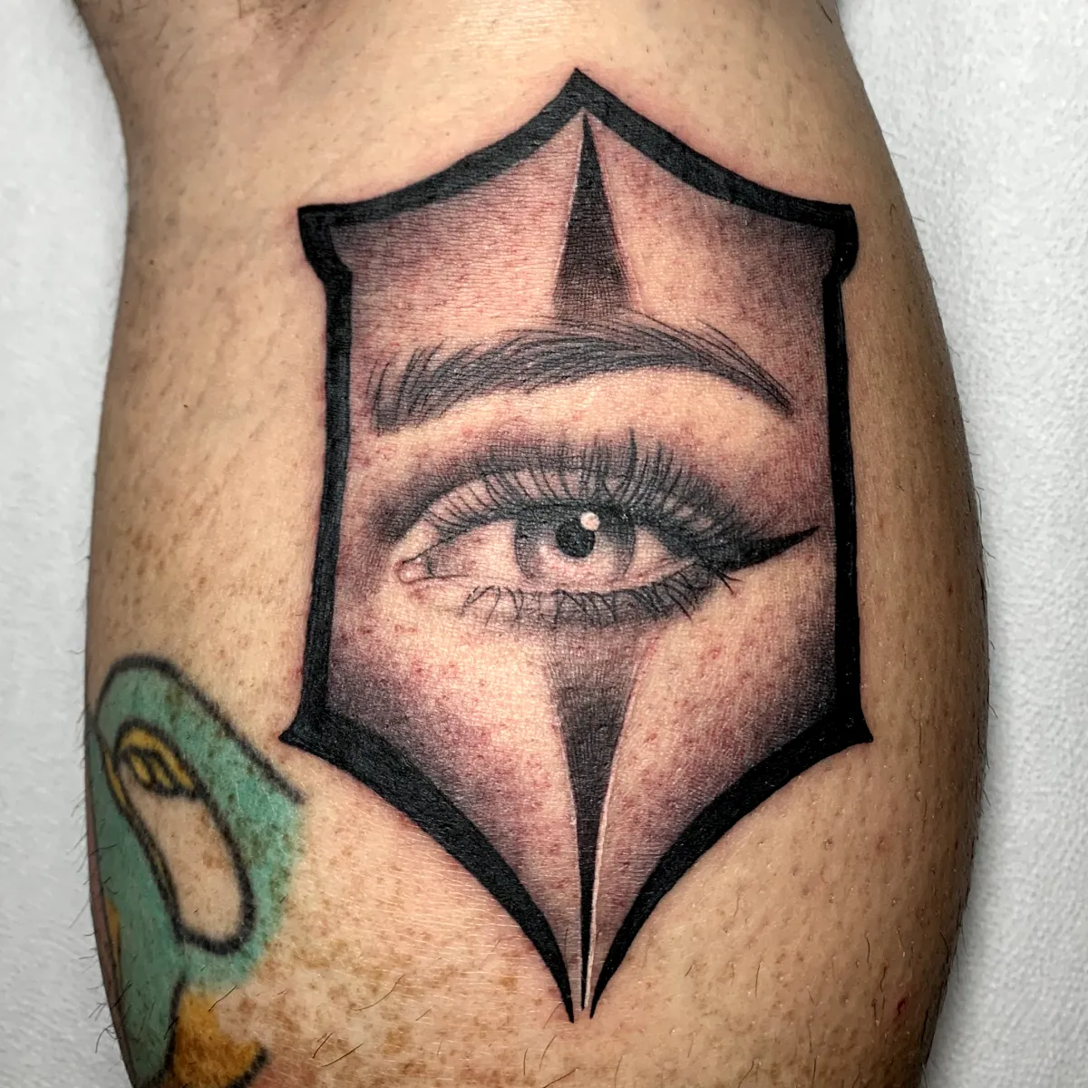 Ojo tatuado en estilo realista